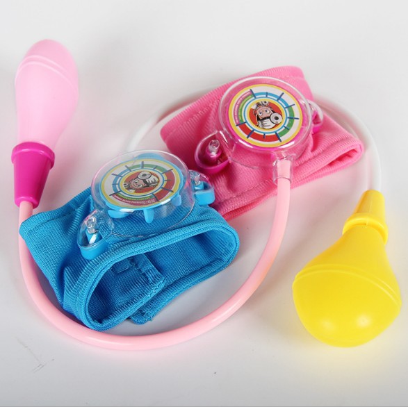 A child&#039;s imitation family doctor&#039;s toy takes blood pressure of a little doctor and nurse
